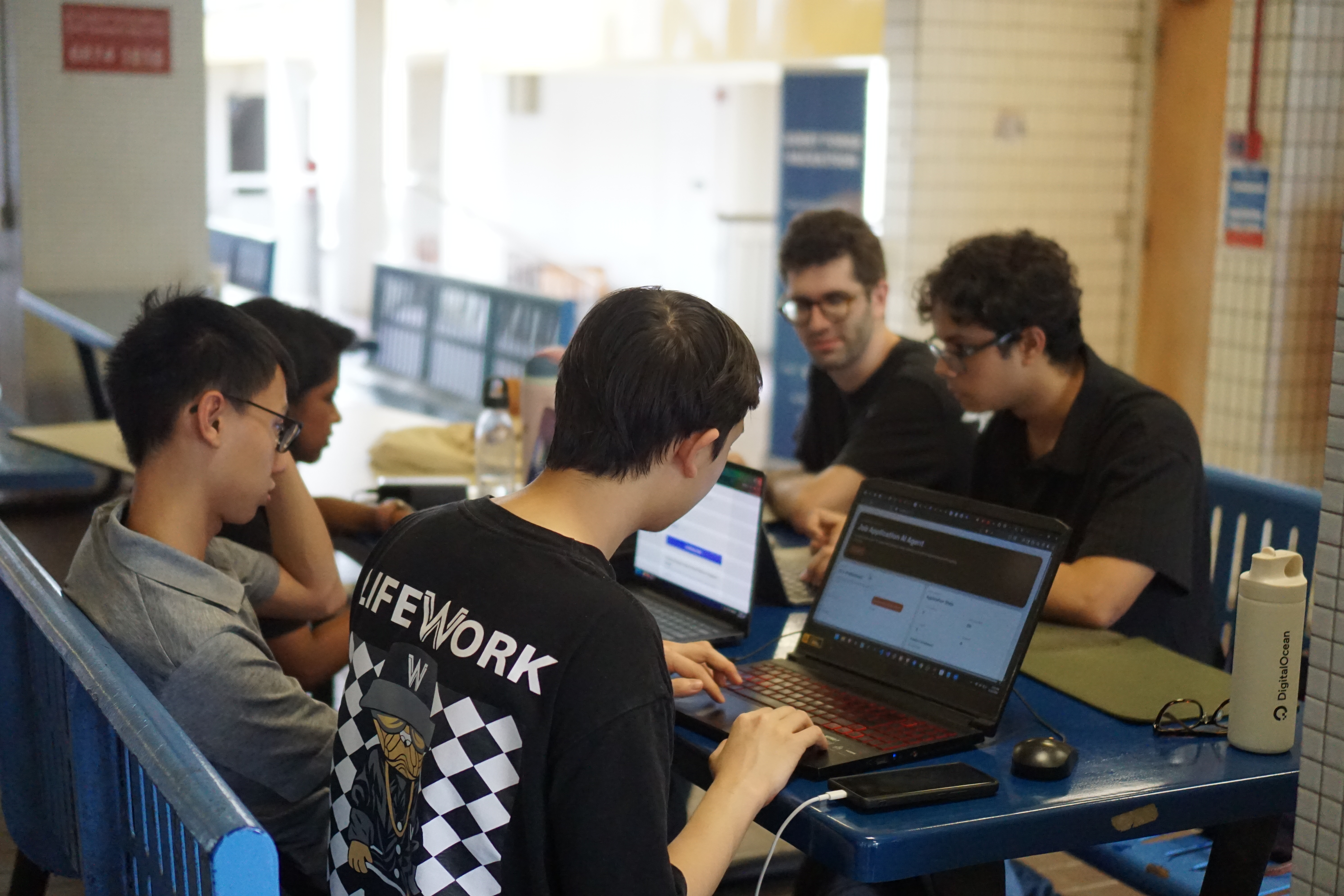 Collaborative side project session with a small team working around laptops.